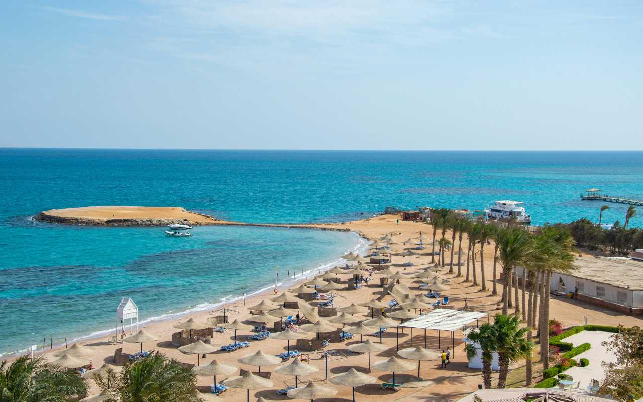 Plaža sa palmama i ležaljkama.