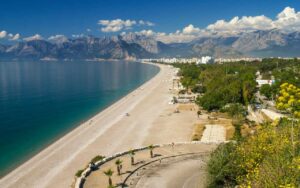 Plaža okružena šumom i planinama.