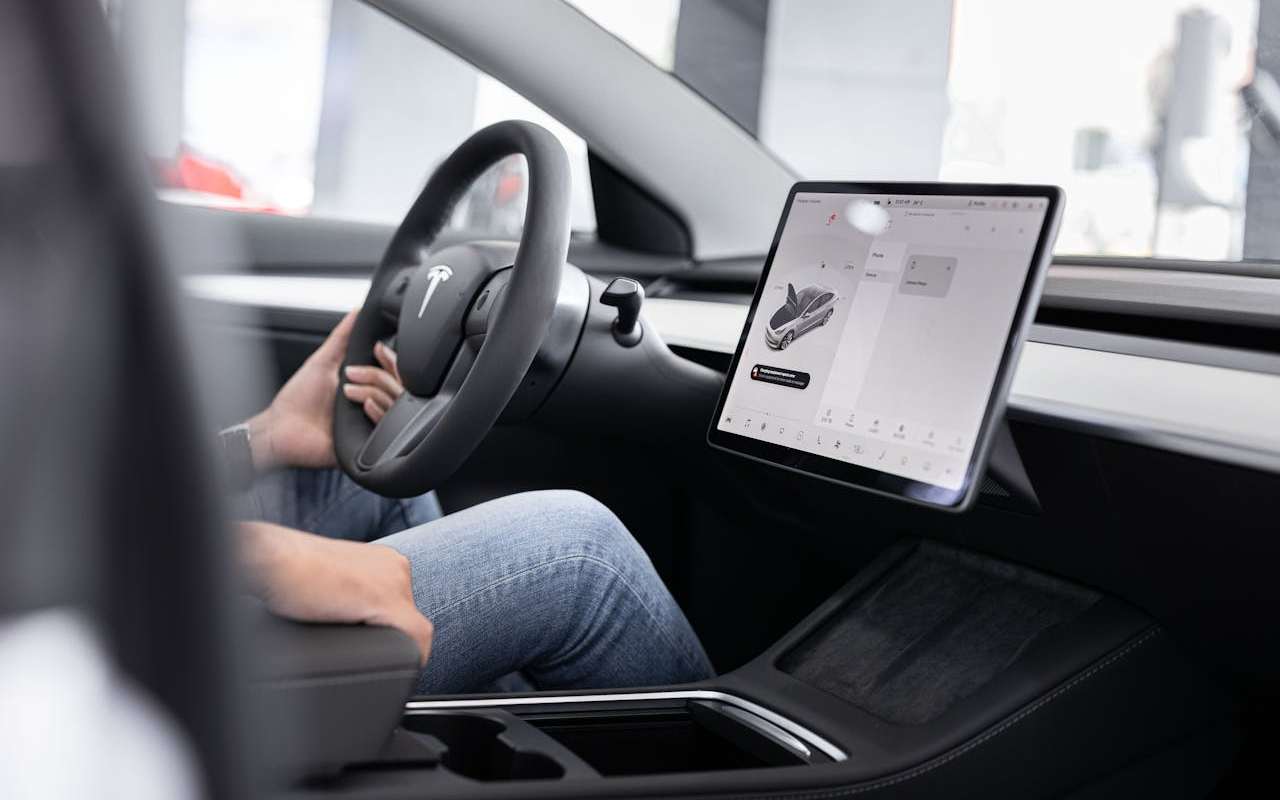 Vozač sedi za volanom automobila.