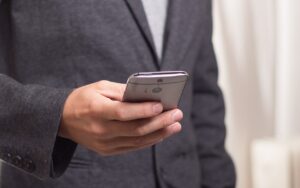 Čovek kuca na mobilnom telefonu.
