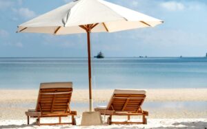 Dve ležaljke pod suncobranom na plaži