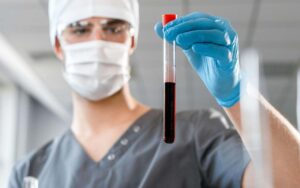 Lekar drži epruvetu punom krvi.