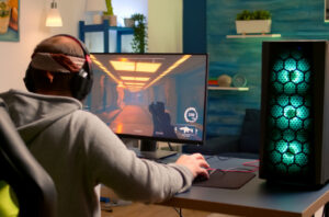 Gejmer sa slušalicama igra igricu na računaru