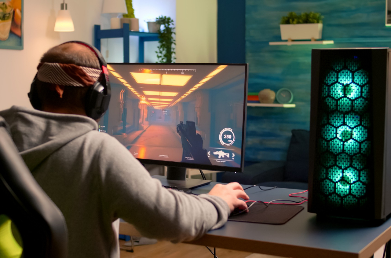Gejmer sa slušalicama igra igricu na računaru