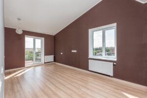 Renoviran prazan stan sa braon zidovima, belim prozorima i belim radijatorima