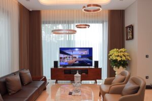 Lepo uređena dnevna soba sa kaučem, foteljama i televizorom