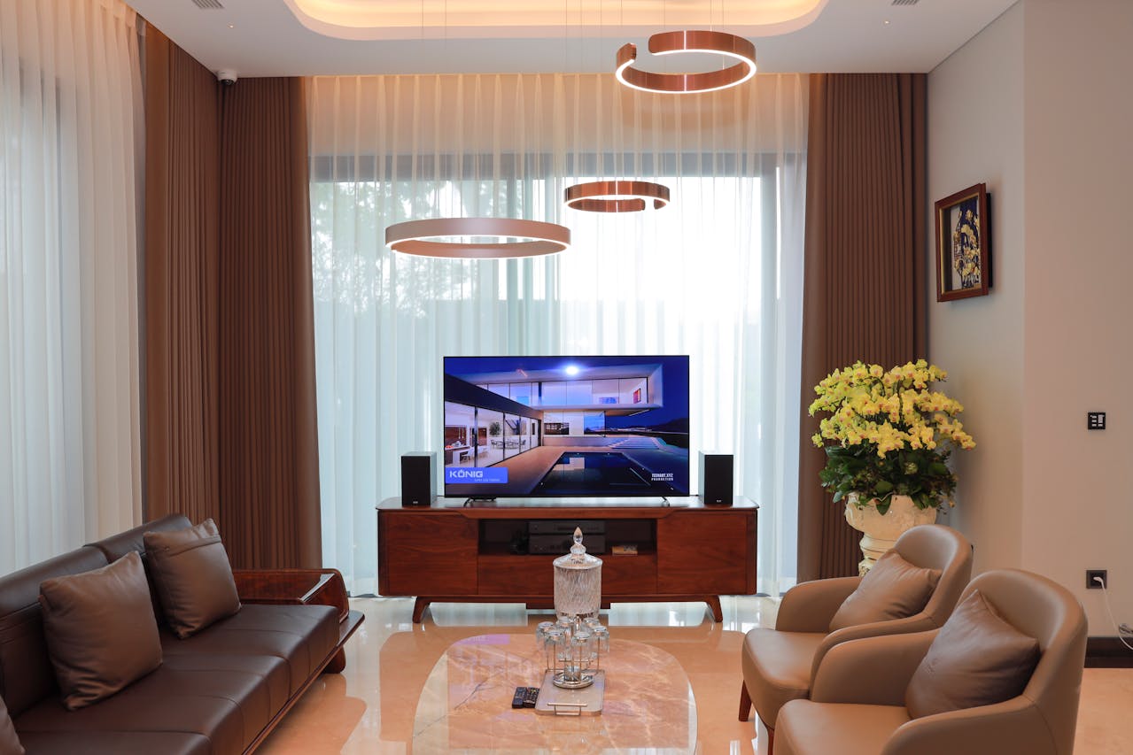 Lepo uređena dnevna soba sa kaučem, foteljama i televizorom