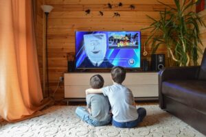 Dva dečaka gledaju crtani na TVu.