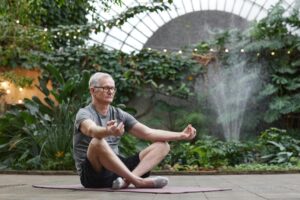 Čovek meditira i radi jogu u parku.